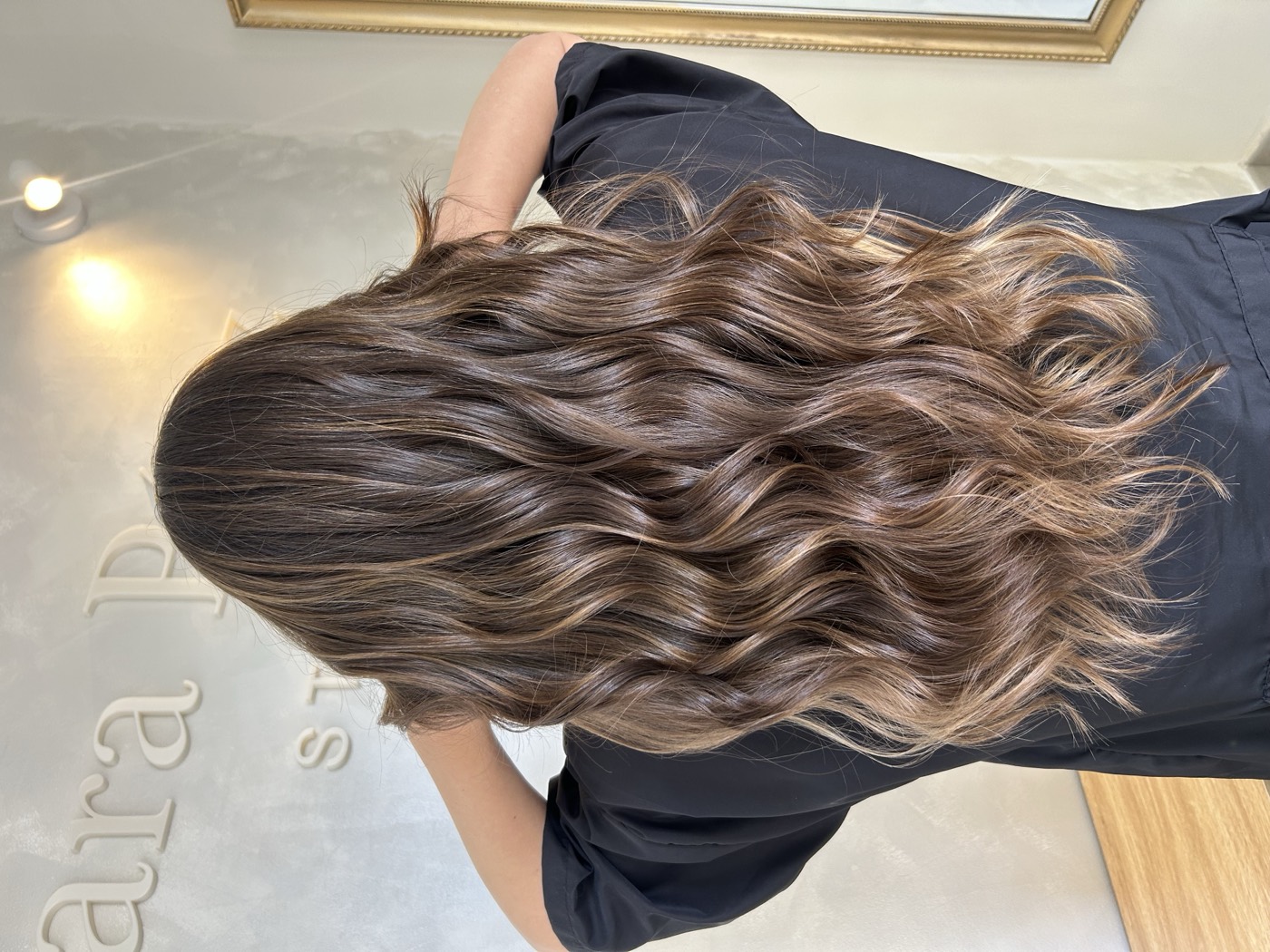 Balayage castaño con reflejos naturales en melena larga ondulada, realizado en Mara Pérez Studio (Tomares, Sevilla)