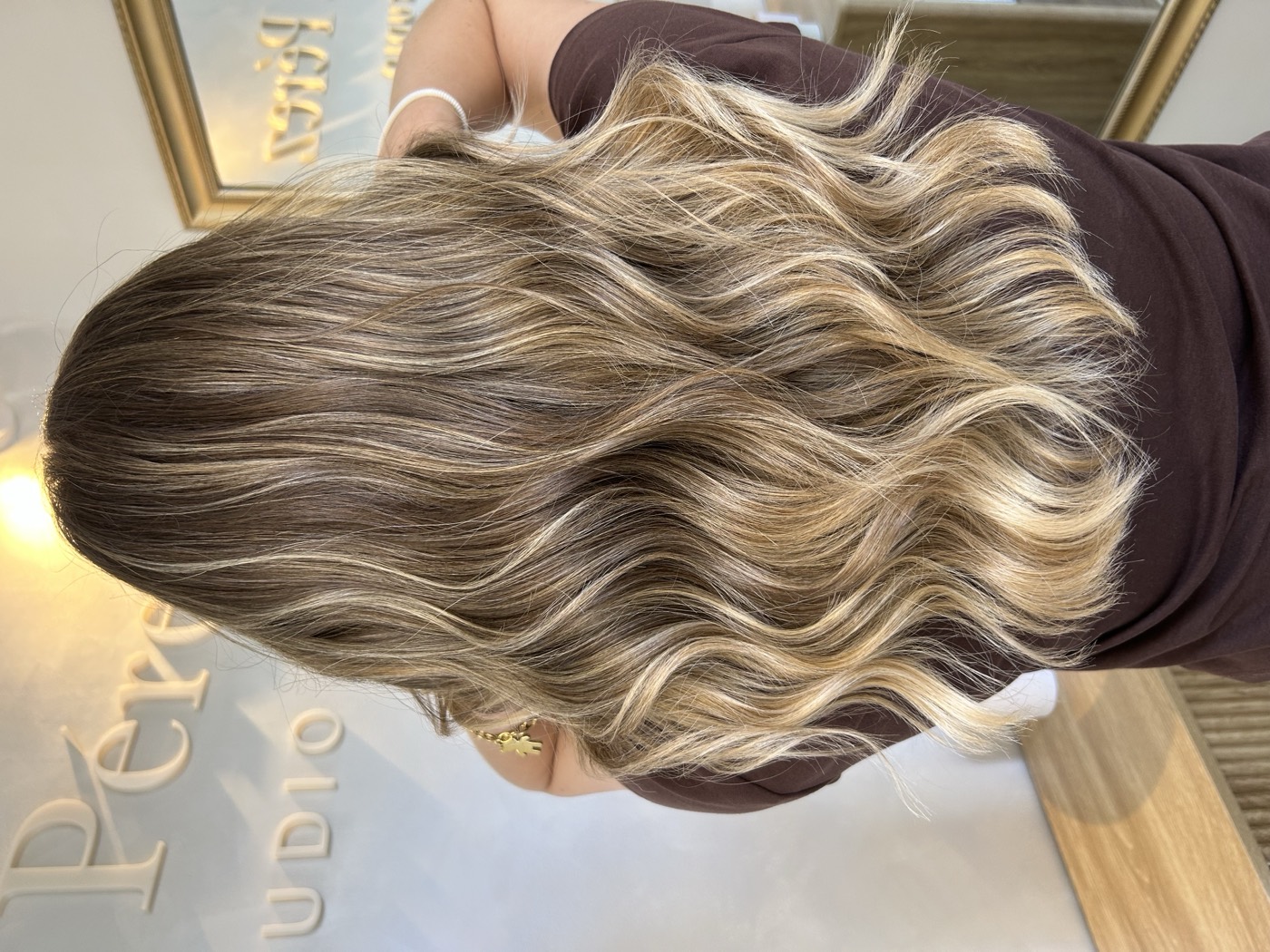 Balayage rubio con efecto sunkiss en melena ondulada, realizado en Mara Pérez Studio (Tomares, Sevilla)
