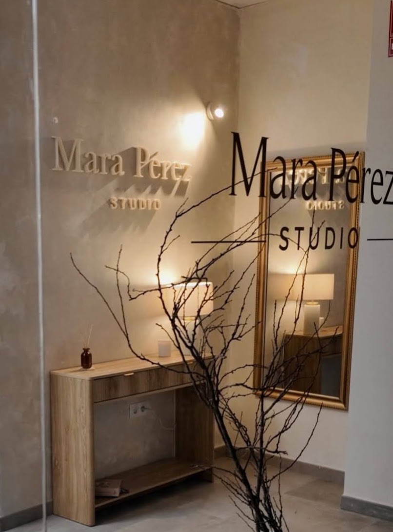 Recepción del salón Mara Pérez Studio en Tomares (Sevilla) con rótulo en pared y espejo dorado